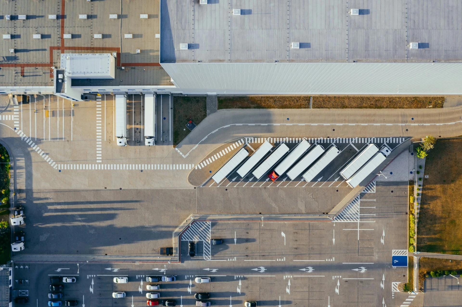 modern-warehouse-and-logistics-facility-for-a-used-clothing-wholesaler View from above at the parking lot next to the used clothing sorting facility warehouse