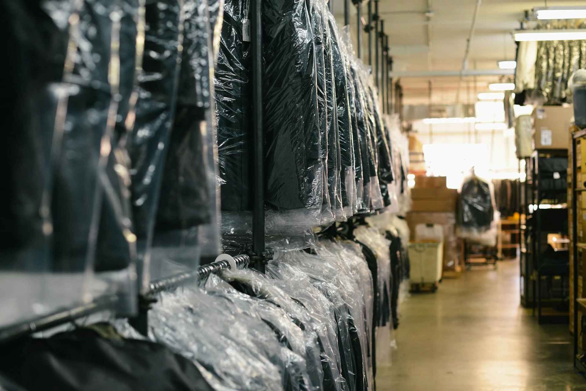 Classic suits after dry cleaning on a clothing rack in a store Elegant black men's suits on a hanger as an example of premium class used clothing